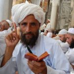 An Afghan 'Hajji' (pilgrim) raises his index finger to denote a central precept of Islam, while holding a Quran in the other hand, during a scene from Parvez Sharma's film "A Sinner in Mecca." Photo courtesy of Haram Films, 2015