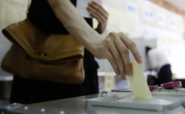 A woman casts her ballot at a polling station in Tokyo July 21, 2013. Prime Minister Shinzo Abe's ruling bloc looks set for a handsome upper house election win on Sunday, cementing his grip on power and setting the stage for Japan's first stable government since the charismatic Junichiro Koizumi left office in 2006. REUTERS/Yuya Shino (JAPAN - Tags: ELECTIONS POLITICS) - RTX11TFE